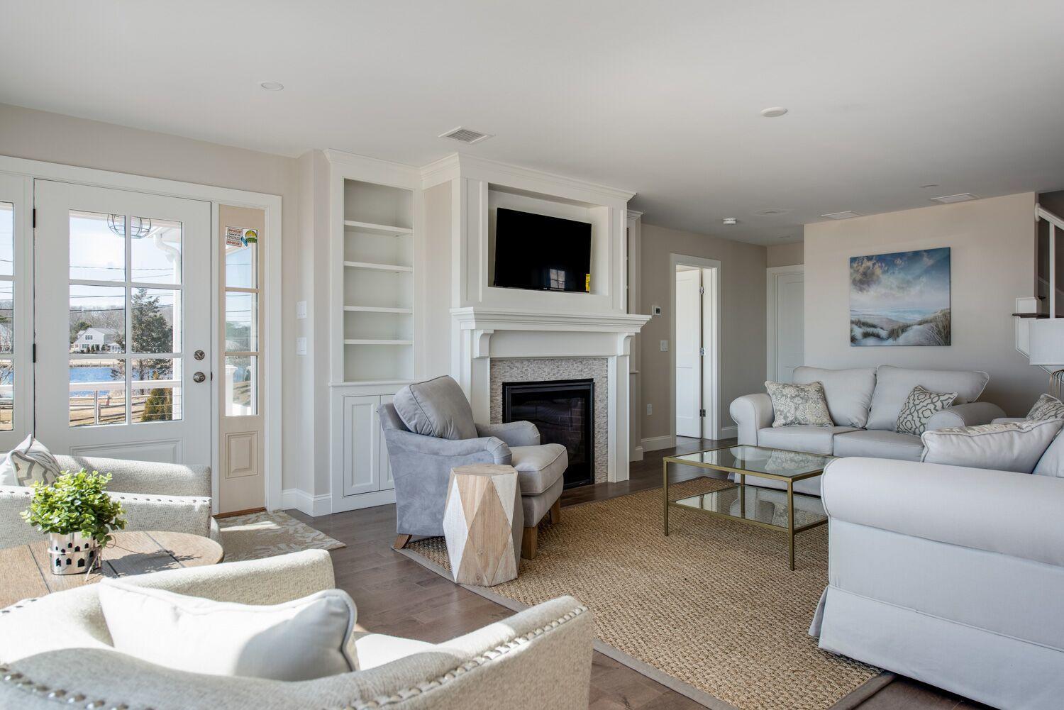 6 Beach Road Mashpee, MA 02649 - Photo 3 of 25 a living room with furniture a flat screen tv and a fireplace