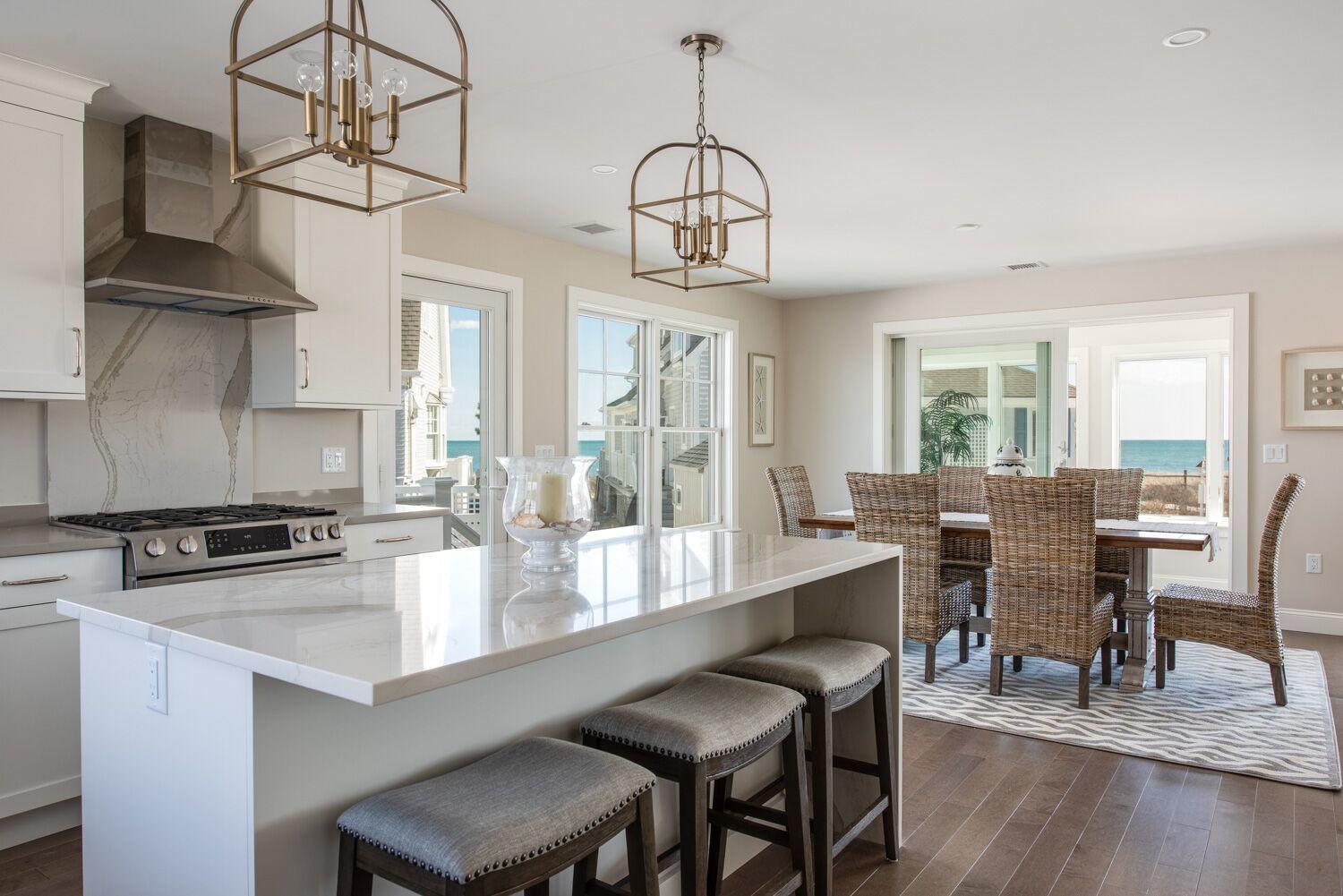 6 Beach Road Mashpee, MA 02649 - Photo 9 of 25 a dining room with wooden floor a chandelier a wooden table and chairs