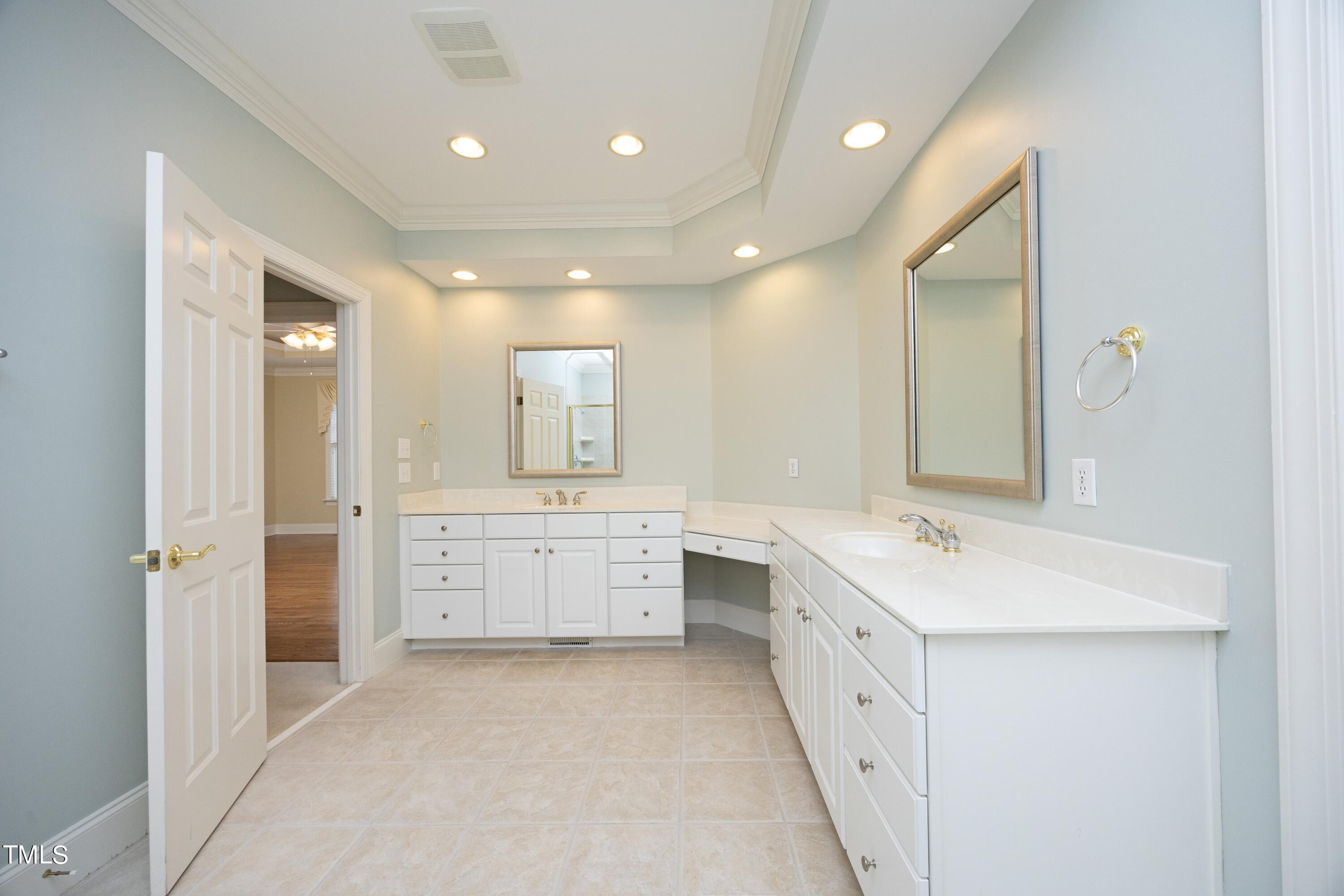 8805 Leeshire Lane Raleigh, NC 27615 - Photo 14 of 26 a large bathroom with a double vanity sink a large mirror and a shower