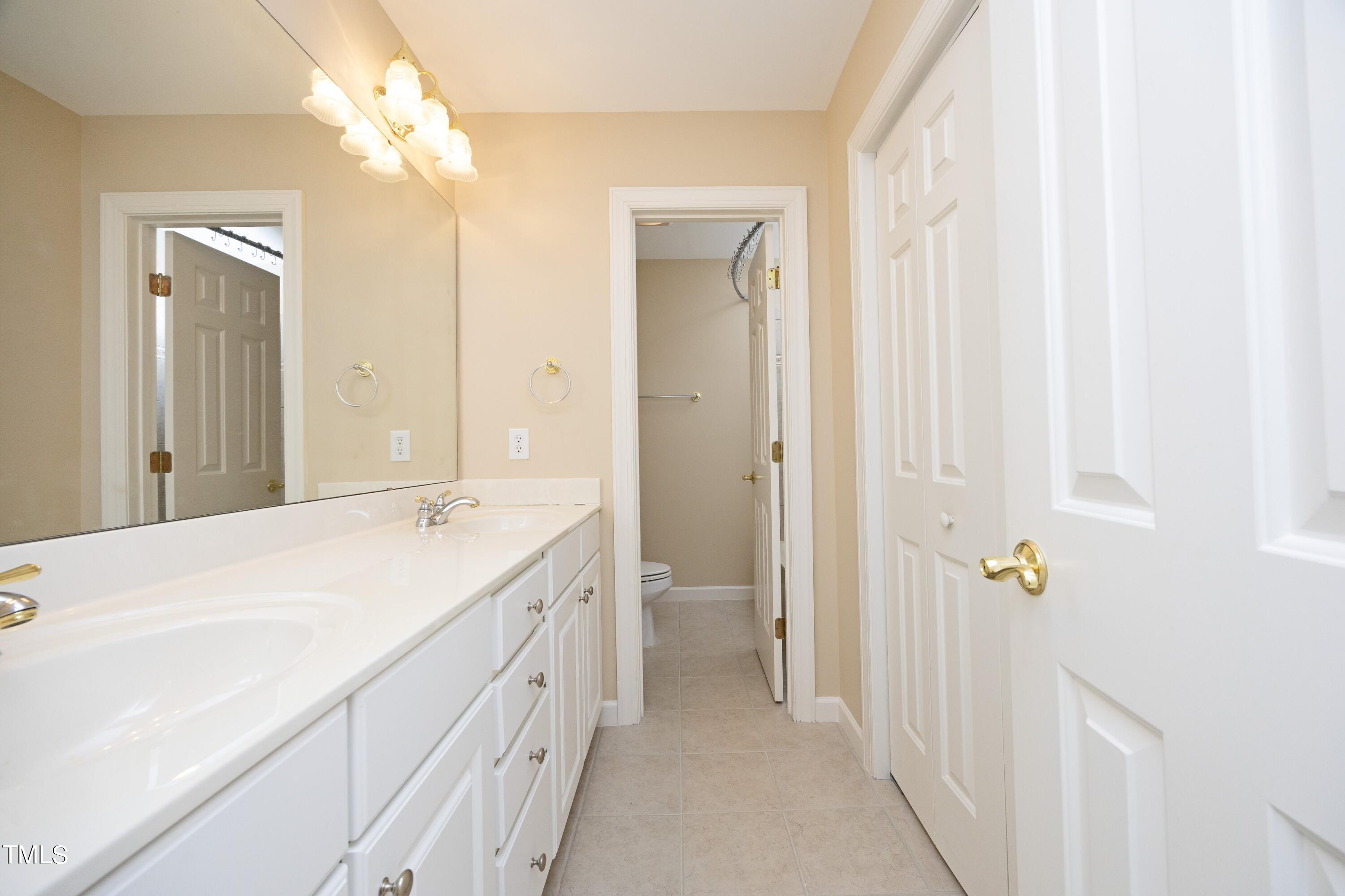 8805 Leeshire Lane Raleigh, NC 27615 - Photo 23 of 26 a spacious bathroom with a double vanity sink a mirror and a shower