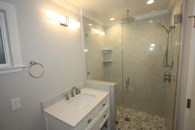 a bathroom with a sink a shower a mirror and a shower