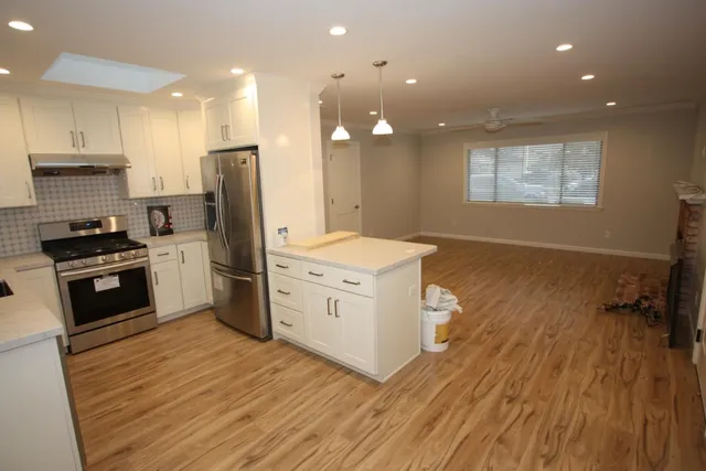a kitchen with a refrigerator and a stove top oven
