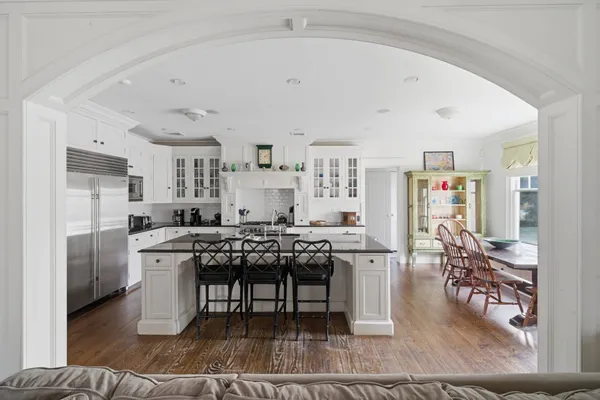 a living room with stainless steel appliances kitchen island granite countertop furniture and a rug
