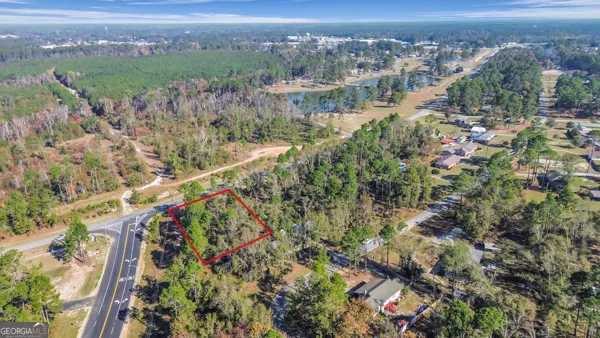 an aerial view of residential houses with outdoor space and trees