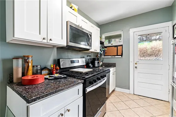 a kitchen with stainless steel appliances granite countertop a stove and a microwave