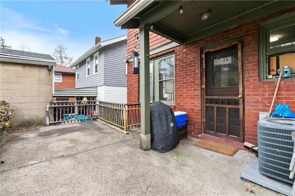 a view of a house with a barbeque and wooden stairs