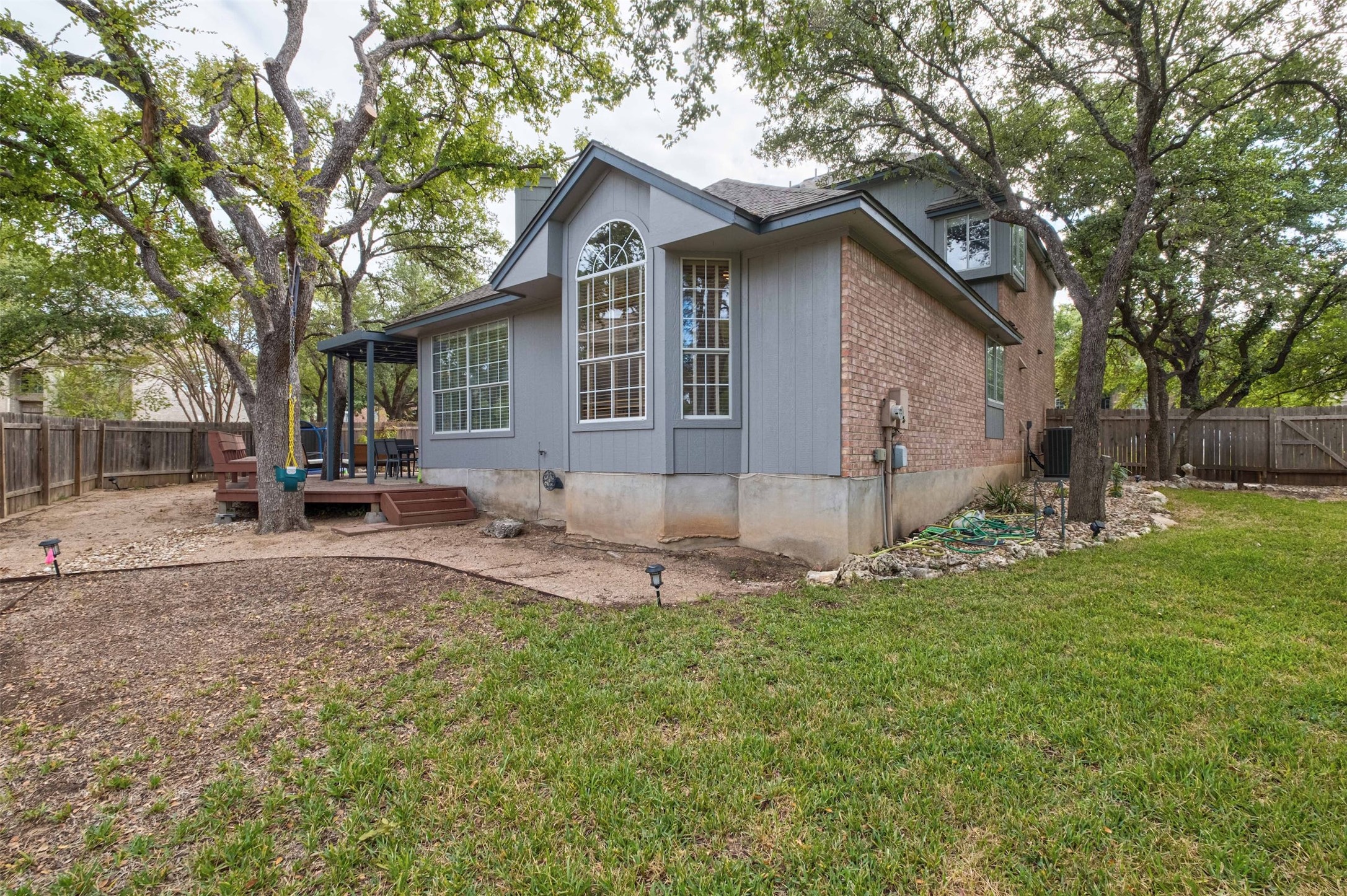 3704 Runnels Court Austin, TX 78732 - Photo 24 of 30 Rear view of house featuring brick siding, a fenced backyard, a wooden deck