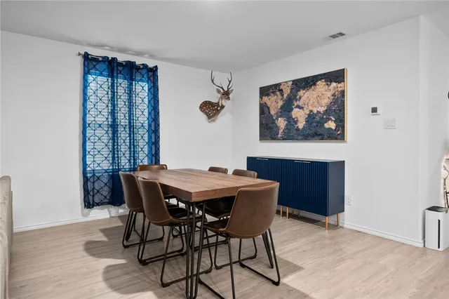 a living room with furniture a dining table and a window