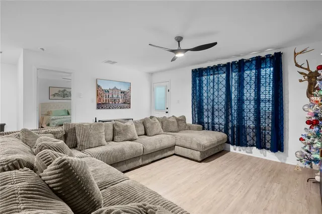 a living room with furniture and a ceiling fan