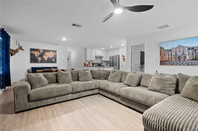 a spacious bedroom with a bed and a chandelier