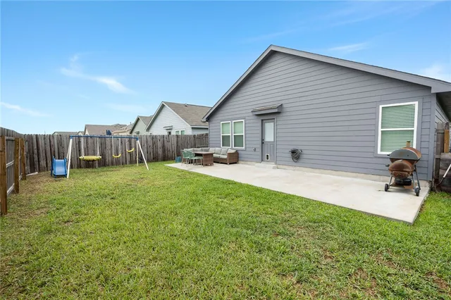 a view of a house with backyard and sitting area