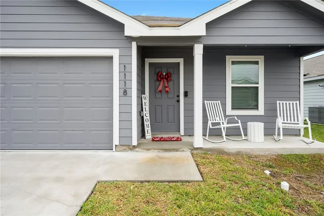 a view of a hallway with wooden floor and a bathroom