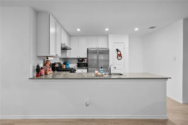 a kitchen with stainless steel appliances granite countertop a refrigerator and a sink