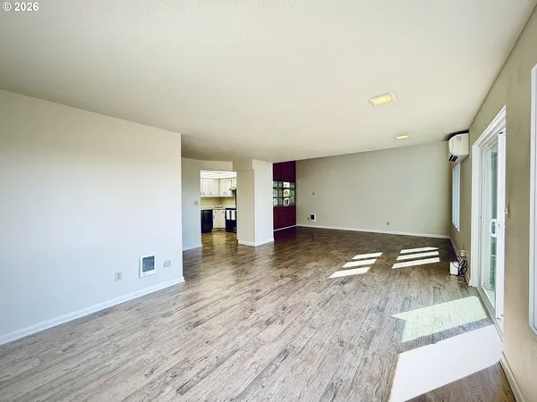 a view of empty room with wooden floor and window