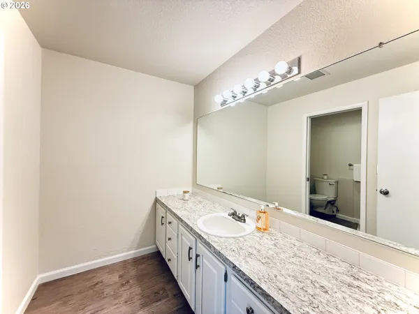 a bathroom with a granite countertop sink and a mirror