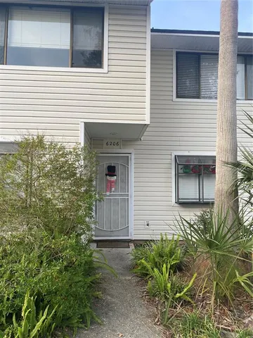 a front view of a house with plants