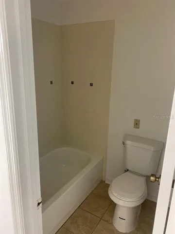 a white toilet sitting next to a bath tub