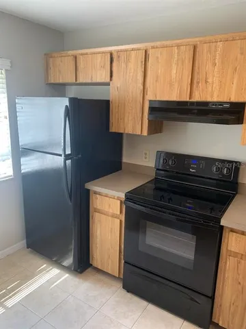 a kitchen with granite countertop a refrigerator and a sink