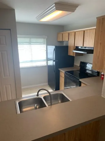 a kitchen with a sink a stove and a window