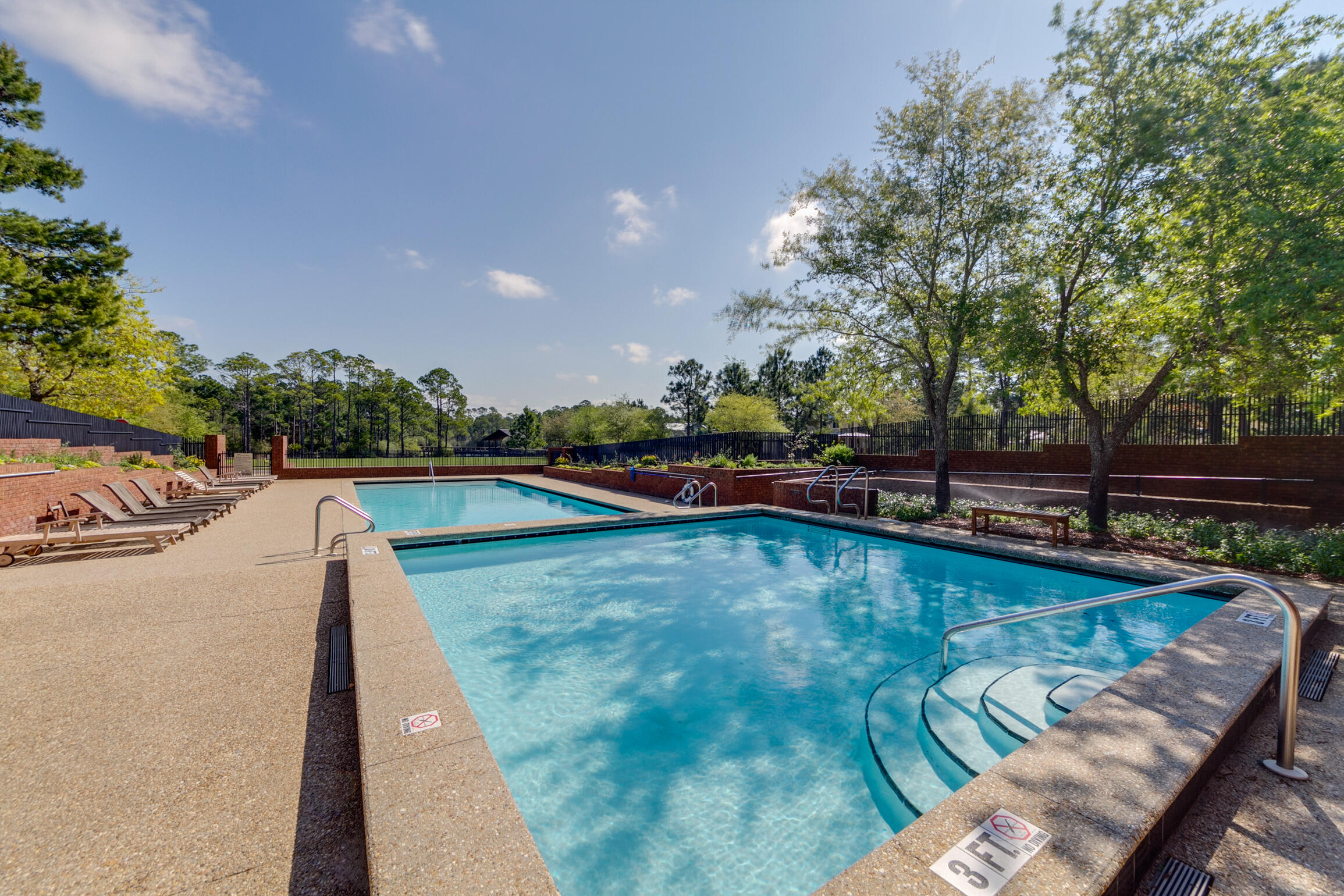 34 Okeechobee West Santa Rosa Beach, FL 32459 - Photo 45 of 91 a view of a swimming pool with a bench and trees in the background