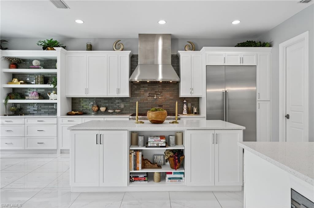14690 Reserve Place Naples, FL 34109 - Photo 13 of 48 Kitchen featuring open shelves, backsplash, wall chimney exhaust hood, built in refrigerator, and white cabinetry