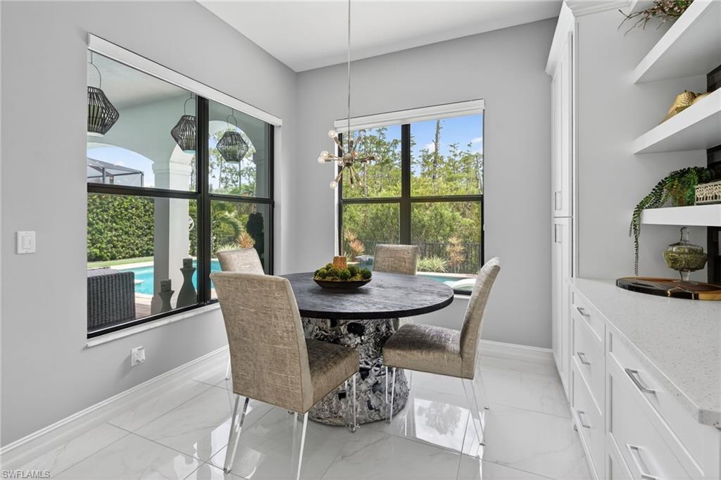14690 Reserve Place Naples, FL 34109 - Photo 14 of 48 Dining area with light marble finish flooring and a chandelier