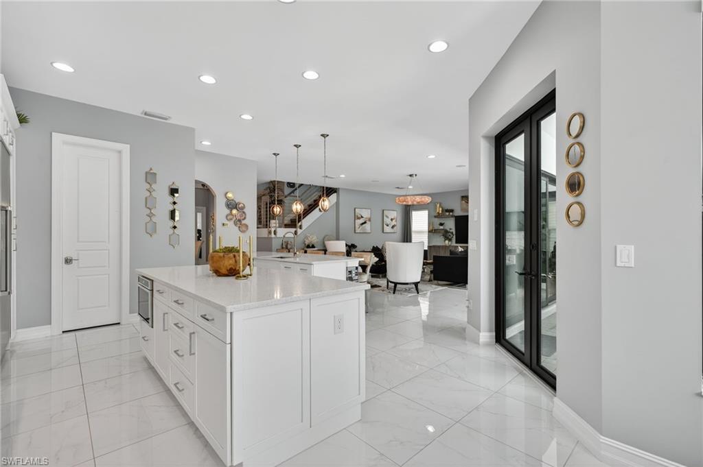 14690 Reserve Place Naples, FL 34109 - Photo 17 of 48 Kitchen with white cabinetry, hanging light fixtures, a center island, recessed lighting, and light marble finish floors