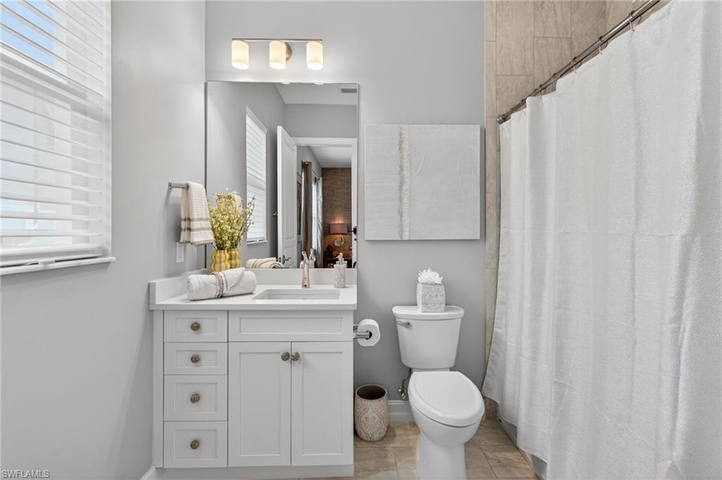 14690 Reserve Place Naples, FL 34109 - Photo 21 of 48 Full bath with vanity, curtained shower, and plenty of natural light