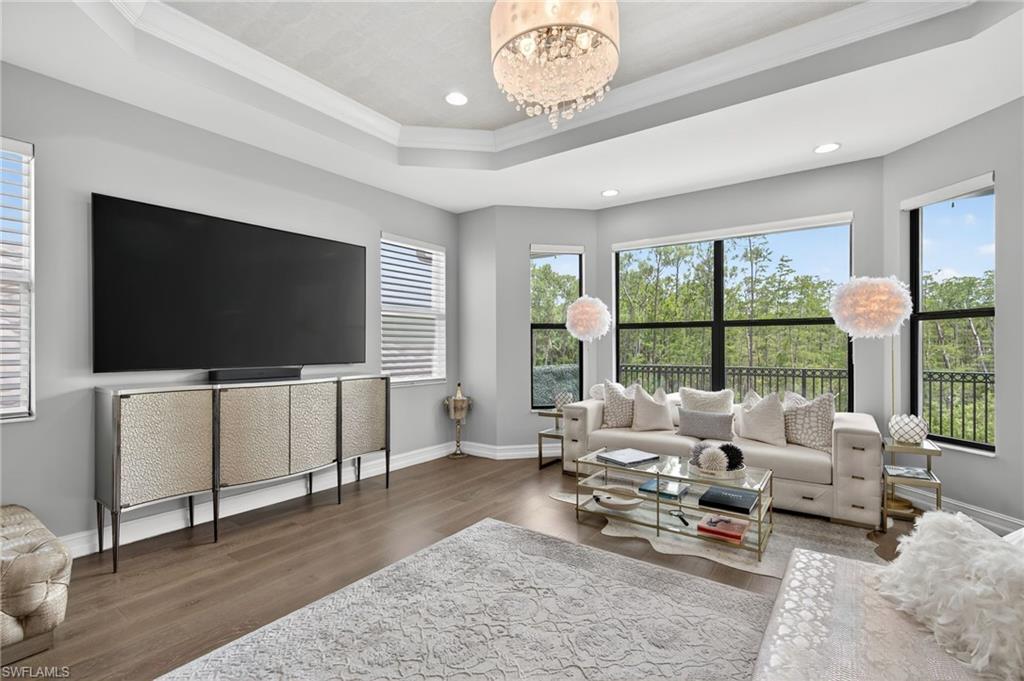14690 Reserve Place Naples, FL 34109 - Photo 24 of 48 Living area with wood finished floors, a raised ceiling, crown molding, a chandelier, and recessed lighting