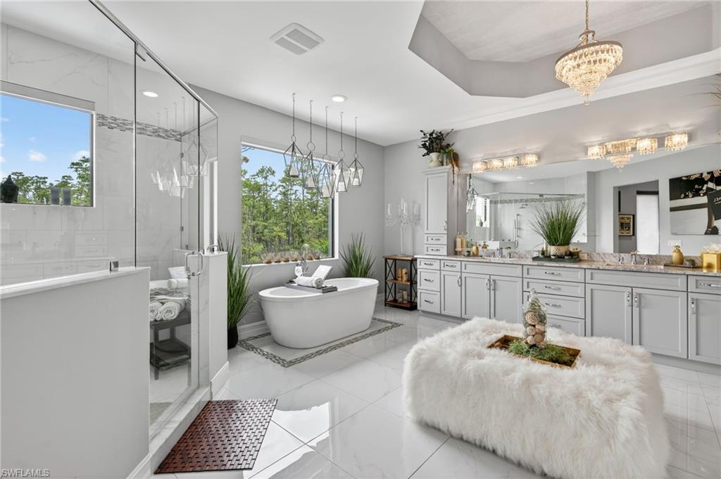 14690 Reserve Place Naples, FL 34109 - Photo 25 of 48 Full bathroom featuring vanity, a shower stall, a freestanding bath, and a chandelier