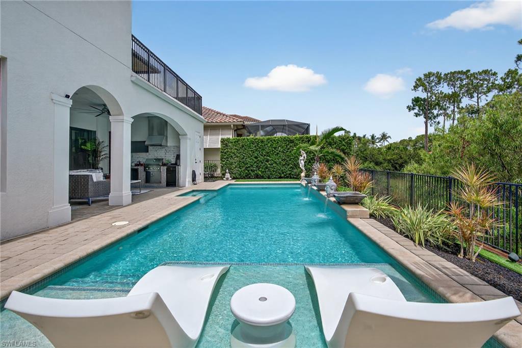 14690 Reserve Place Naples, FL 34109 - Photo 44 of 48 View of swimming pool featuring a patio, a ceiling fan, a fenced backyard, and a balcony