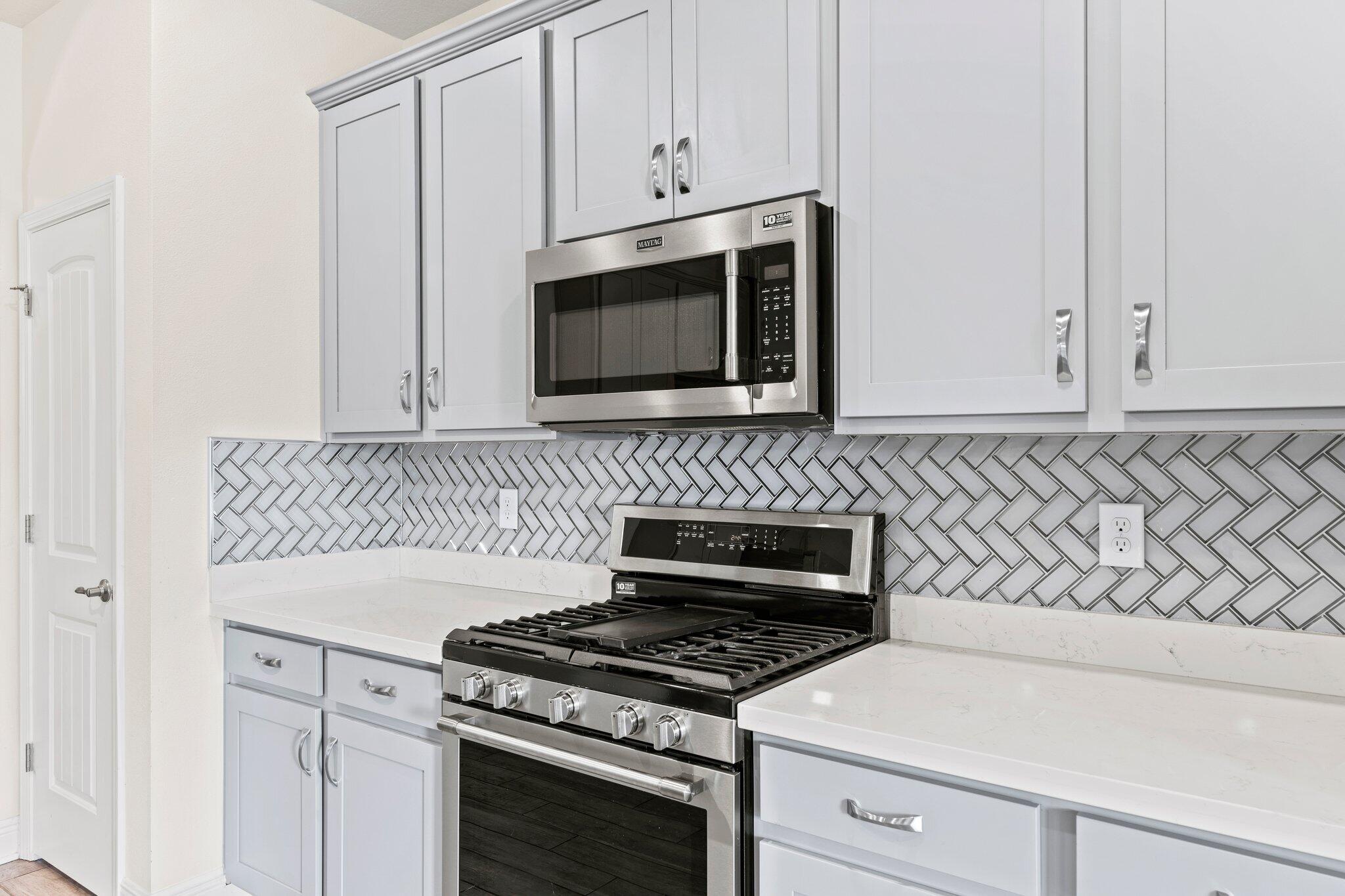 91 Sweet Tea Lane Freeport, FL 32439 - Photo 38 of 80 a kitchen with granite countertop white cabinets and stainless steel appliances