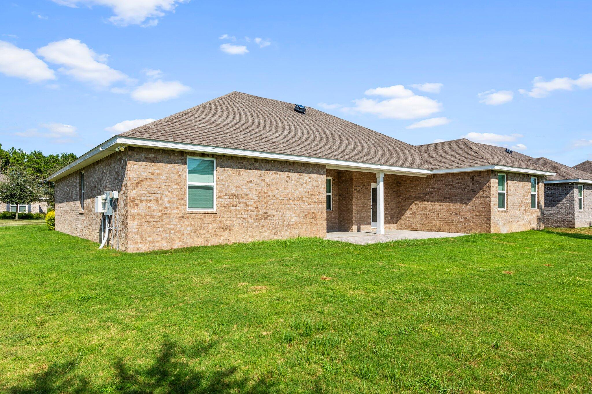 91 Sweet Tea Lane Freeport, FL 32439 - Photo 68 of 80 a view of a yard in front of a house with plants and large tree
