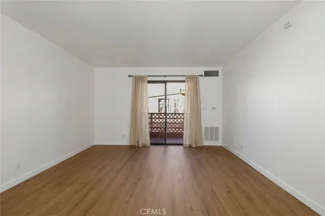 an empty room with wooden floor and a window