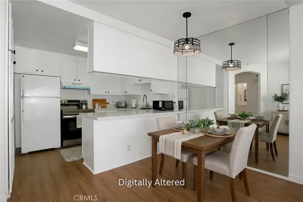 a kitchen with kitchen island a dining table chairs stainless steel appliances and cabinets