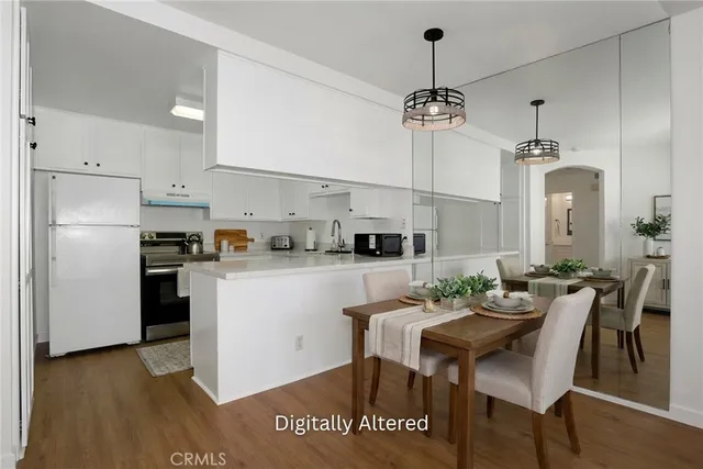 a kitchen with kitchen island a dining table chairs stainless steel appliances and cabinets
