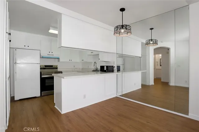 a kitchen with kitchen island white cabinets and refrigerator