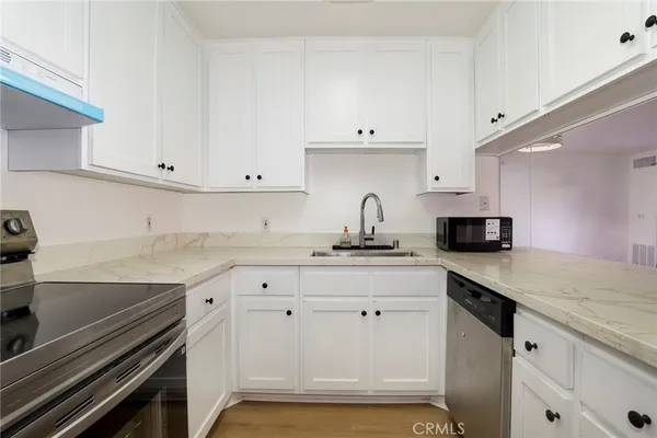 a kitchen with granite countertop a sink and cabinets