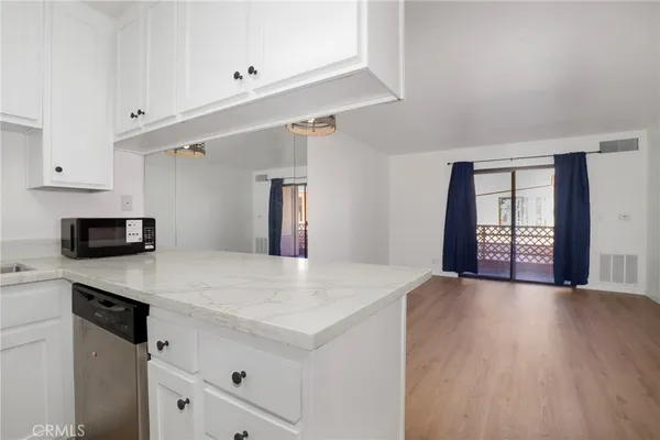 a kitchen with a wooden floor and white cabinets