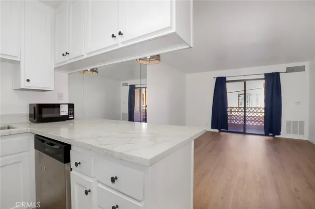 a kitchen with a wooden floor and white cabinets