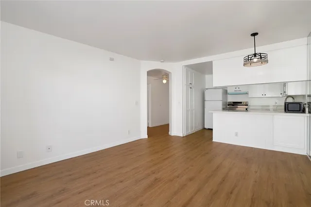 a view of a kitchen with a sink and dishwasher with wooden floor