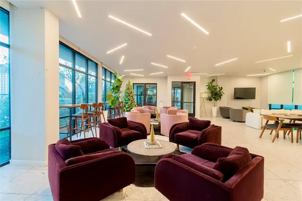 a living room with furniture kitchen view and a large window