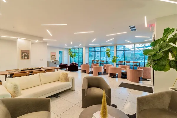 a living room with furniture kitchen and a large window