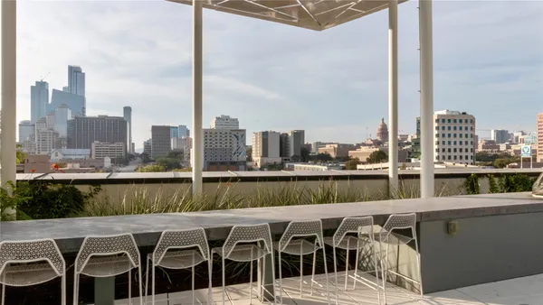 a view of roof deck with chairs and city view