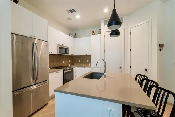 a kitchen with stainless steel appliances a refrigerator and a stove top oven