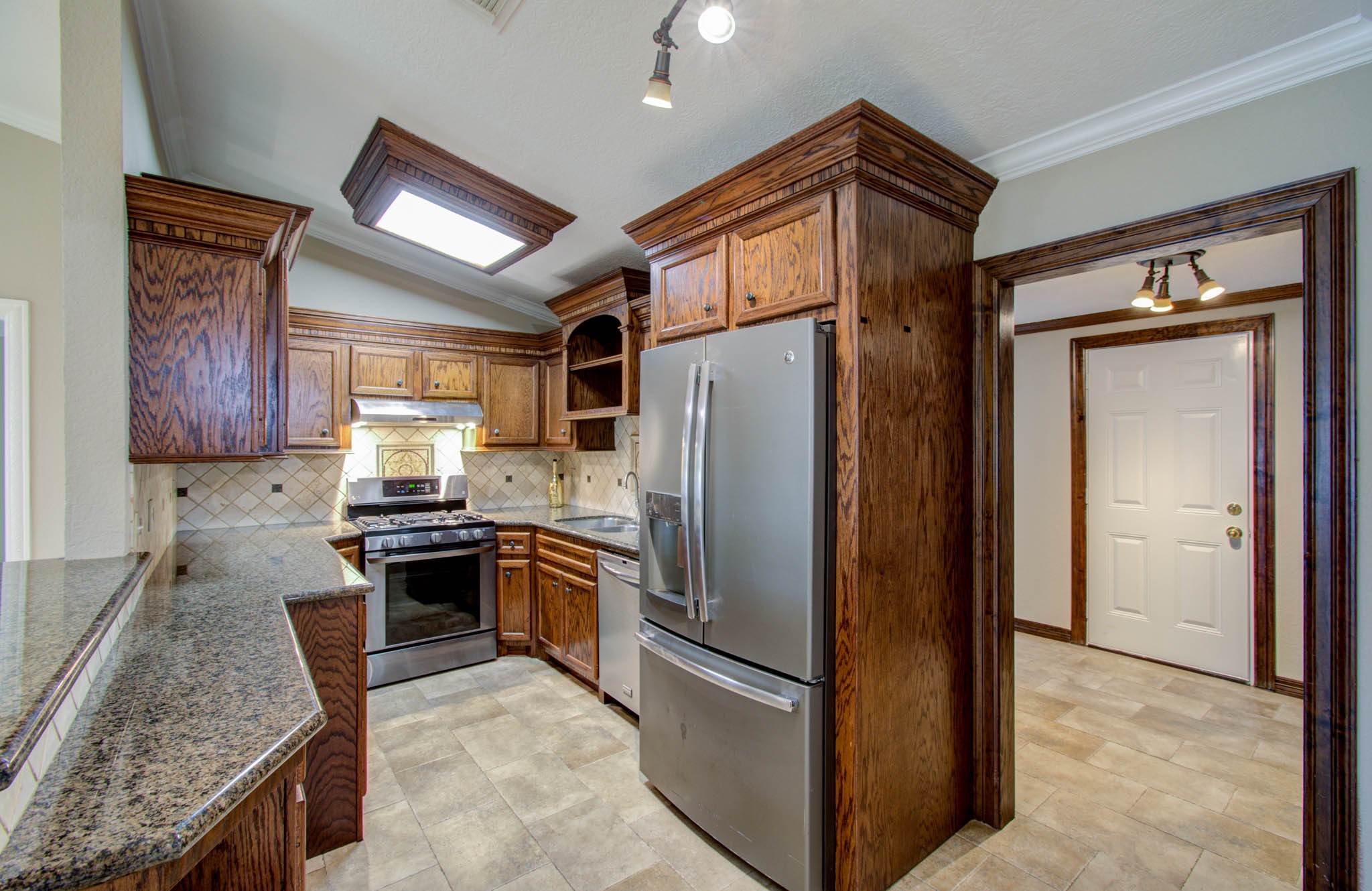 8942 Judwin Street Houston, TX 77075 - Photo 9 of 21 a kitchen with stainless steel appliances granite countertop a refrigerator a stove and a sink