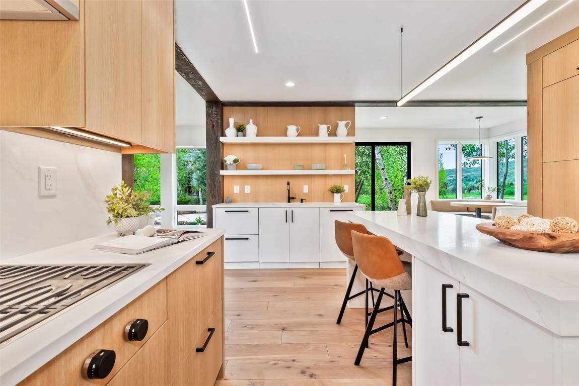 24 Maple Street Steamboat Springs, CO 80487 - Photo 10 of 49 a kitchen with stainless steel appliances kitchen island wooden floors and large windows
