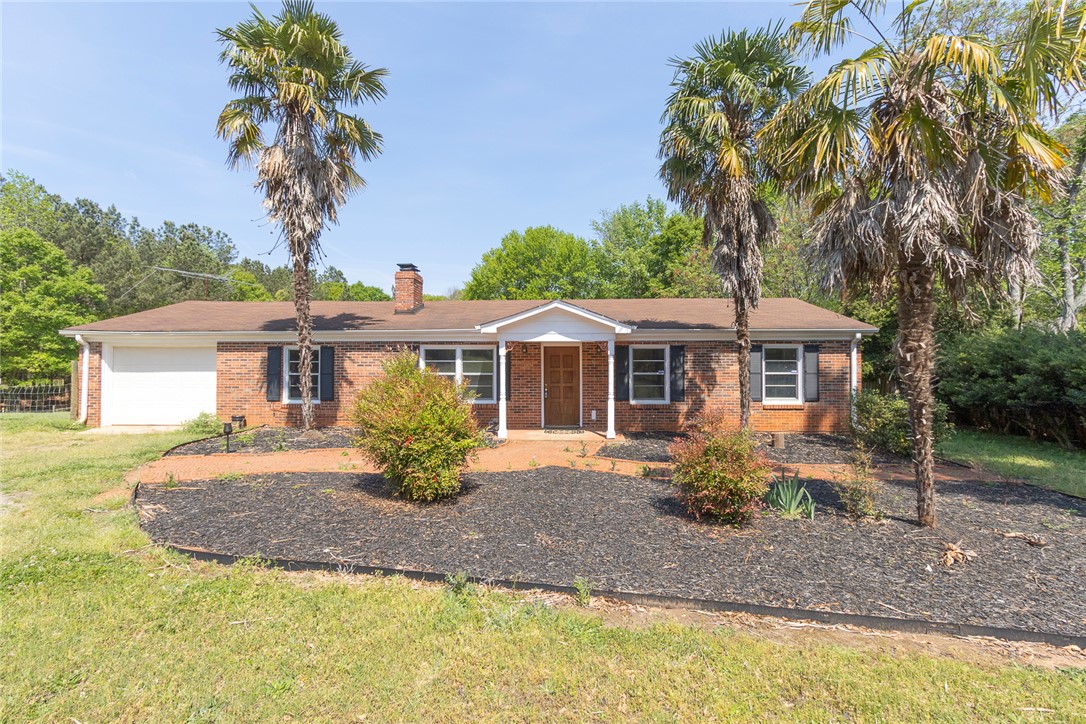 820 Travis Road Anderson, SC 29626 - Photo 3 of 46 This classic brick residence features a welcoming front entry, a well-maintained lawn, and mature palm trees.