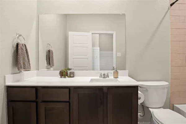a bathroom with a double vanity sink toilet and mirror