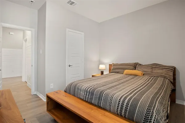 a bedroom with a bed and wooden floor
